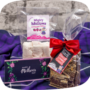 Mother's Day Bark + Mallow Deal: A bag of our Raspberry Ripple Mighty Mallows beside a bag of our Biscoff Lovers Crunch Chocolate Bark and a sample Mother's Day greeting card.